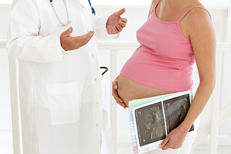 Gynäkologe mit schwangerer Frau im Gespräch
