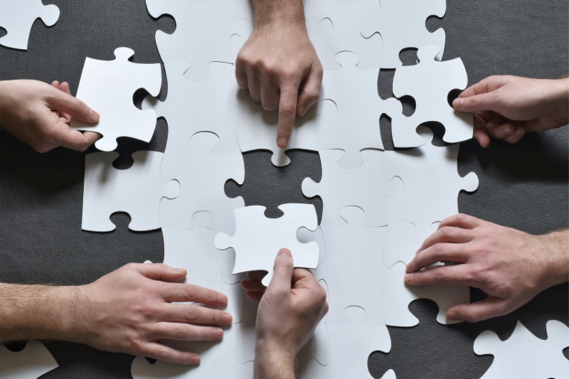 Hände arbeiten an einem Puzzle